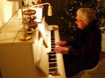 oma speelt kerstliedjes achter de piano