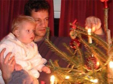 kind bij Kerstboom en lichtje