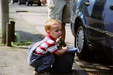 kindje helpt met autowassen